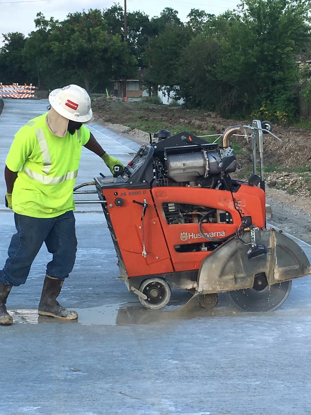 TNT Construction Group operator running a concrete saw on a freshly poured street